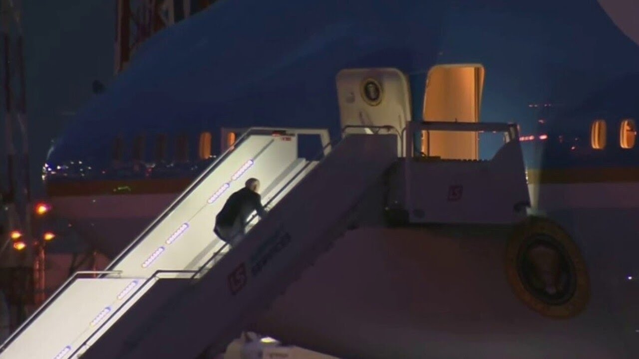 Biden stumbles and falls while walking up steps of Air Force One.